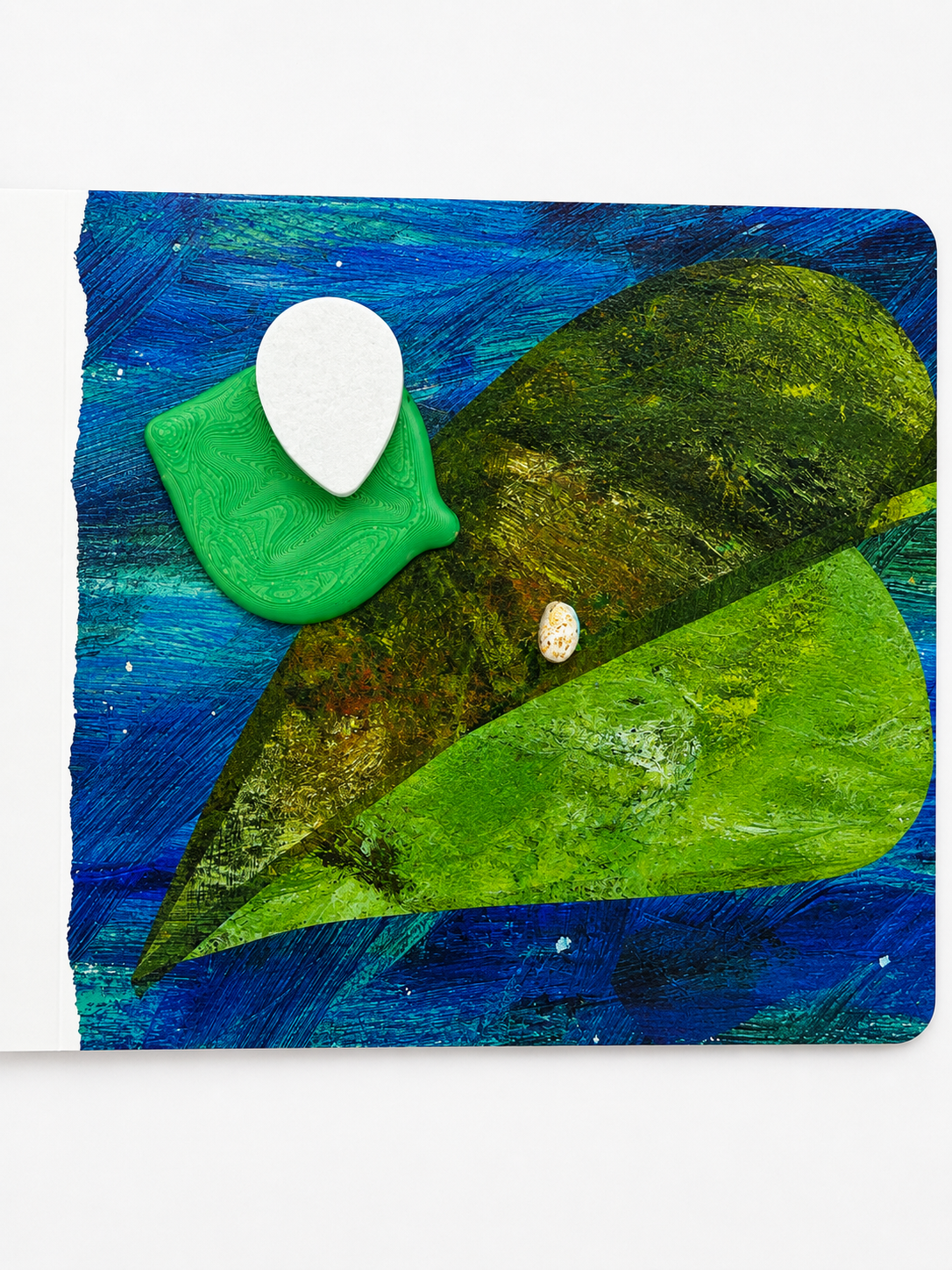 A square mixed-media art print or card featuring abstract green leaf-like forms on a textured blue background, with a small white teardrop-shaped element and a tiny shell detail, shown against a light gray studio background.